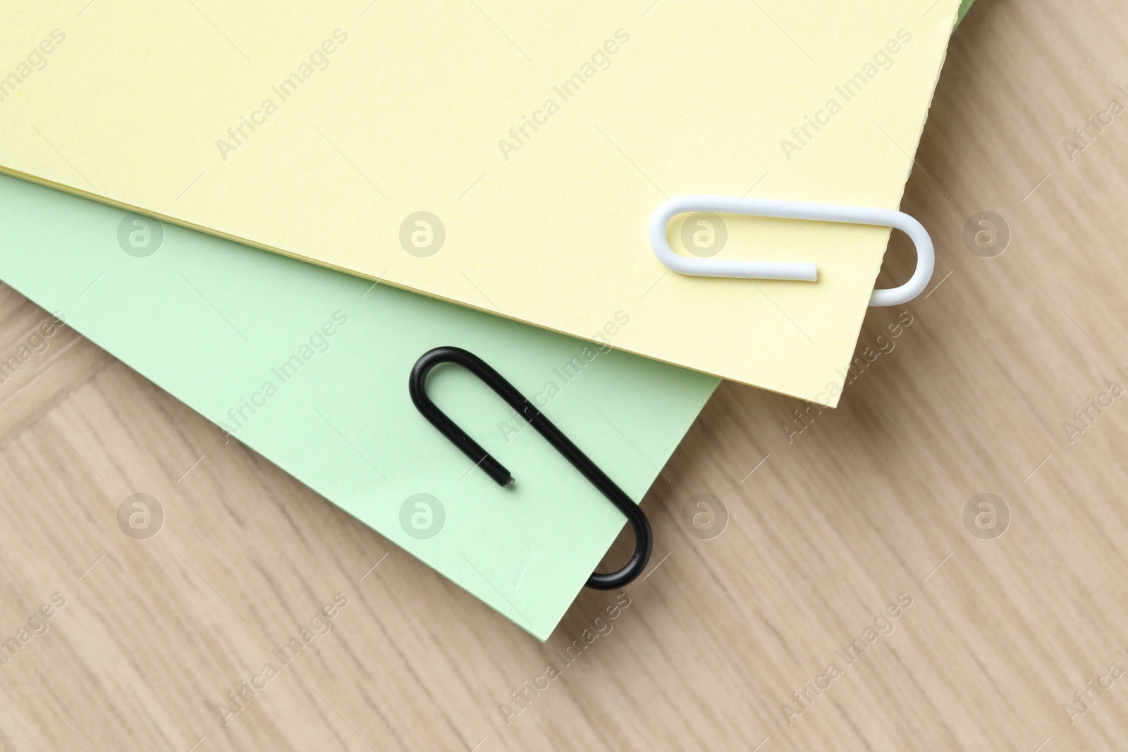 Photo of Paper notes with clips on wooden table, top view