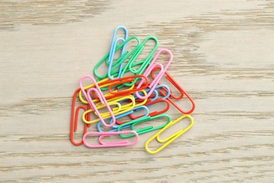 Photo of Many colorful paper clips on wooden table, top view