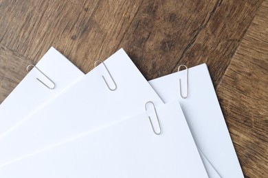 Paper notes with clips on wooden table, top view