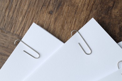 Photo of Paper notes with clips on wooden table, top view