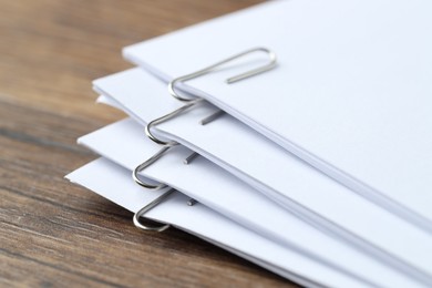 Photo of Paper notes with clips on wooden table, closeup