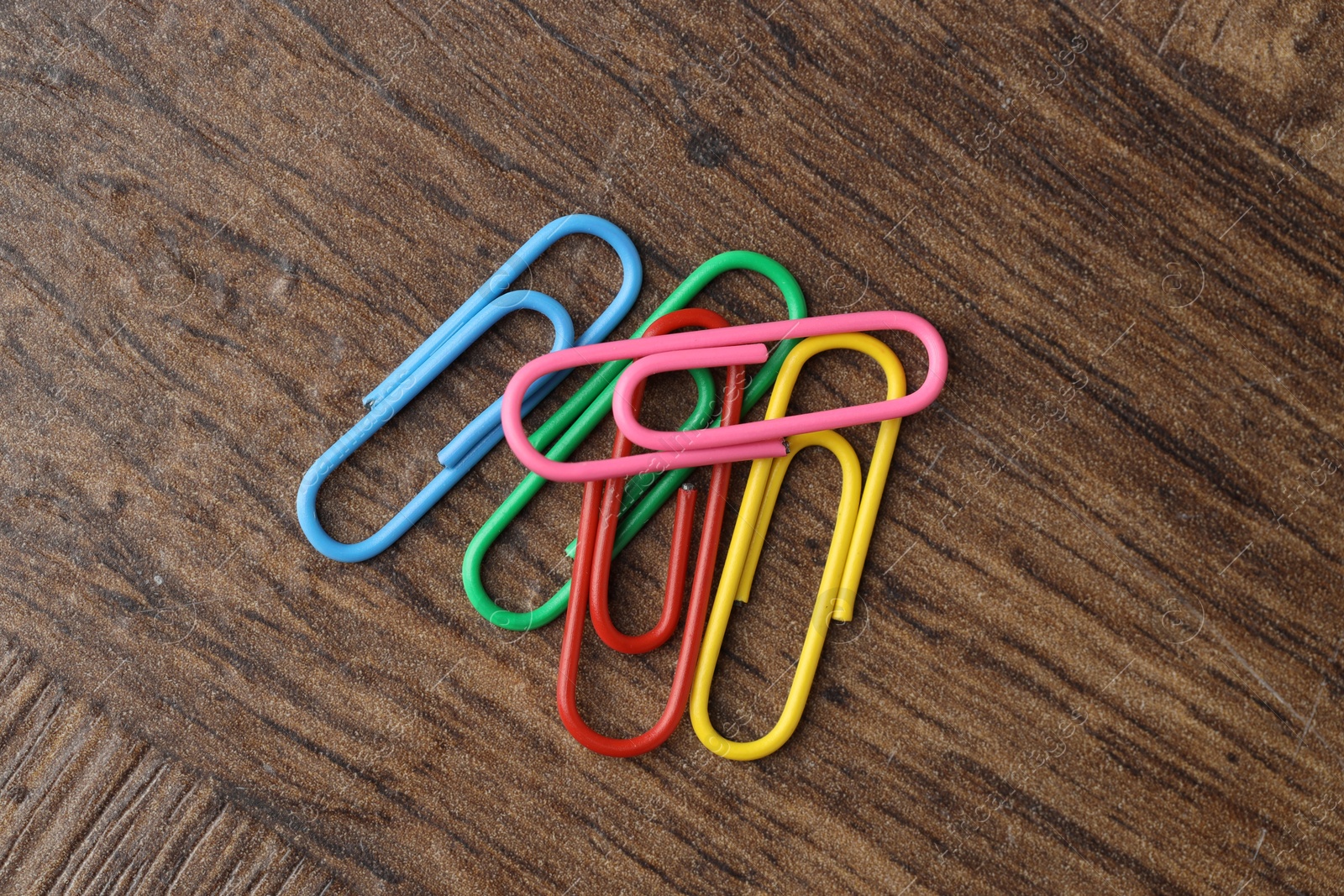 Photo of Many colorful paper clips on wooden table, top view