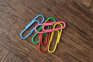 Photo of Many colorful paper clips on wooden table, top view