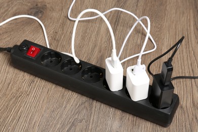 Photo of USB adapters with charge cables in power strip on floor, closeup