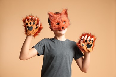 Quadrobics. Boy wearing fox mask and gloves on beige background