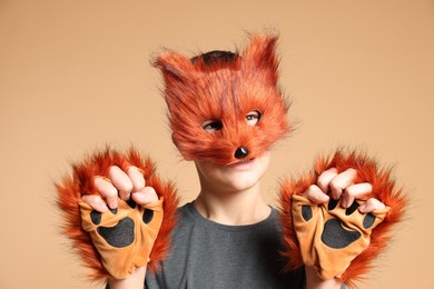 Quadrobics. Boy wearing fox mask and gloves on beige background