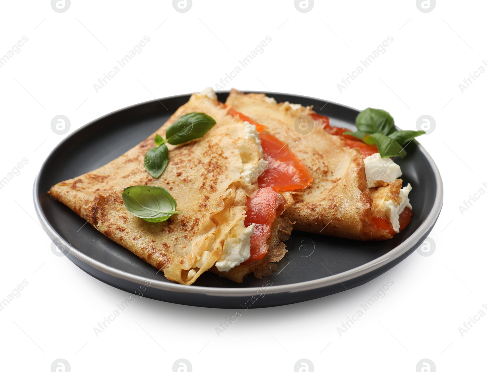 Photo of Delicious crepes with salmon, cream cheese and basil isolated on white