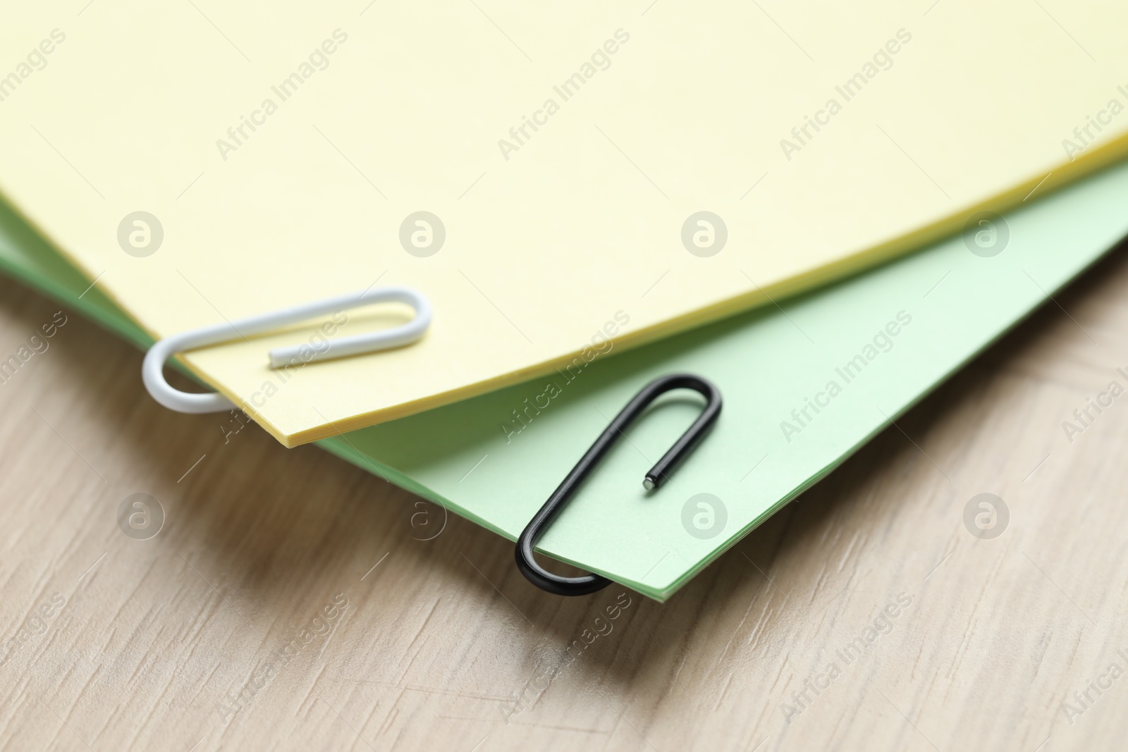 Photo of Paper notes with clips on wooden table, closeup