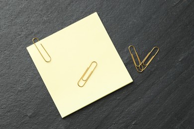 Photo of Paper notes and clips on black table, top view