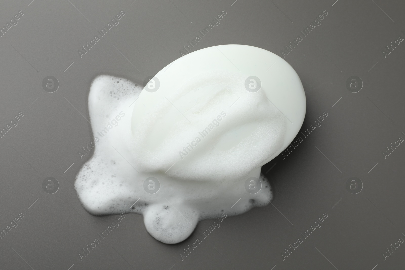 Photo of Soap bar with foam on grey background, top view