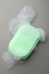 Photo of Soap bar with foam on grey background, top view