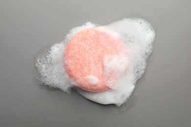 Photo of Soap bar with foam on grey background, top view