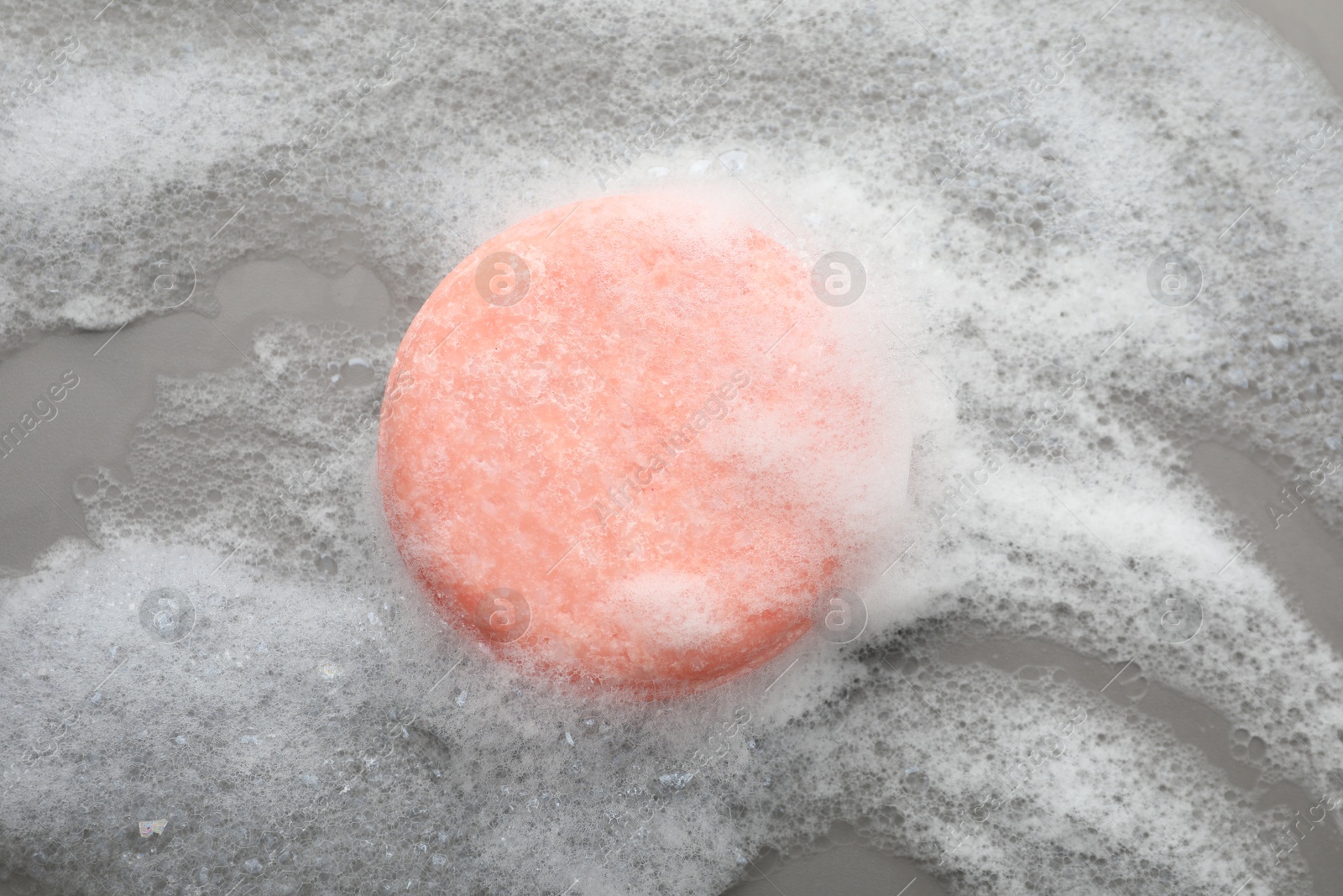 Photo of Soap bar with foam on grey background, top view