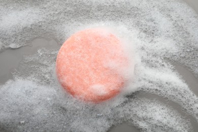 Photo of Soap bar with foam on grey background, top view