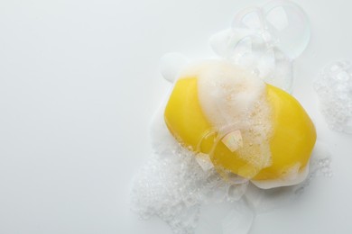 Photo of Soap bar with foam on white background, top view. Space for text