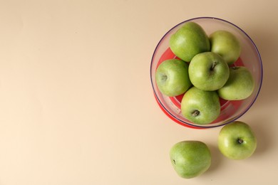 Photo of Kitchen scale with apples on beige background, top view. Space for text