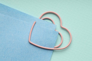 Photo of Paper notes attached with clip on light blue background, top view