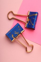 Photo of Binder clips and paper note on pink background, flat lay