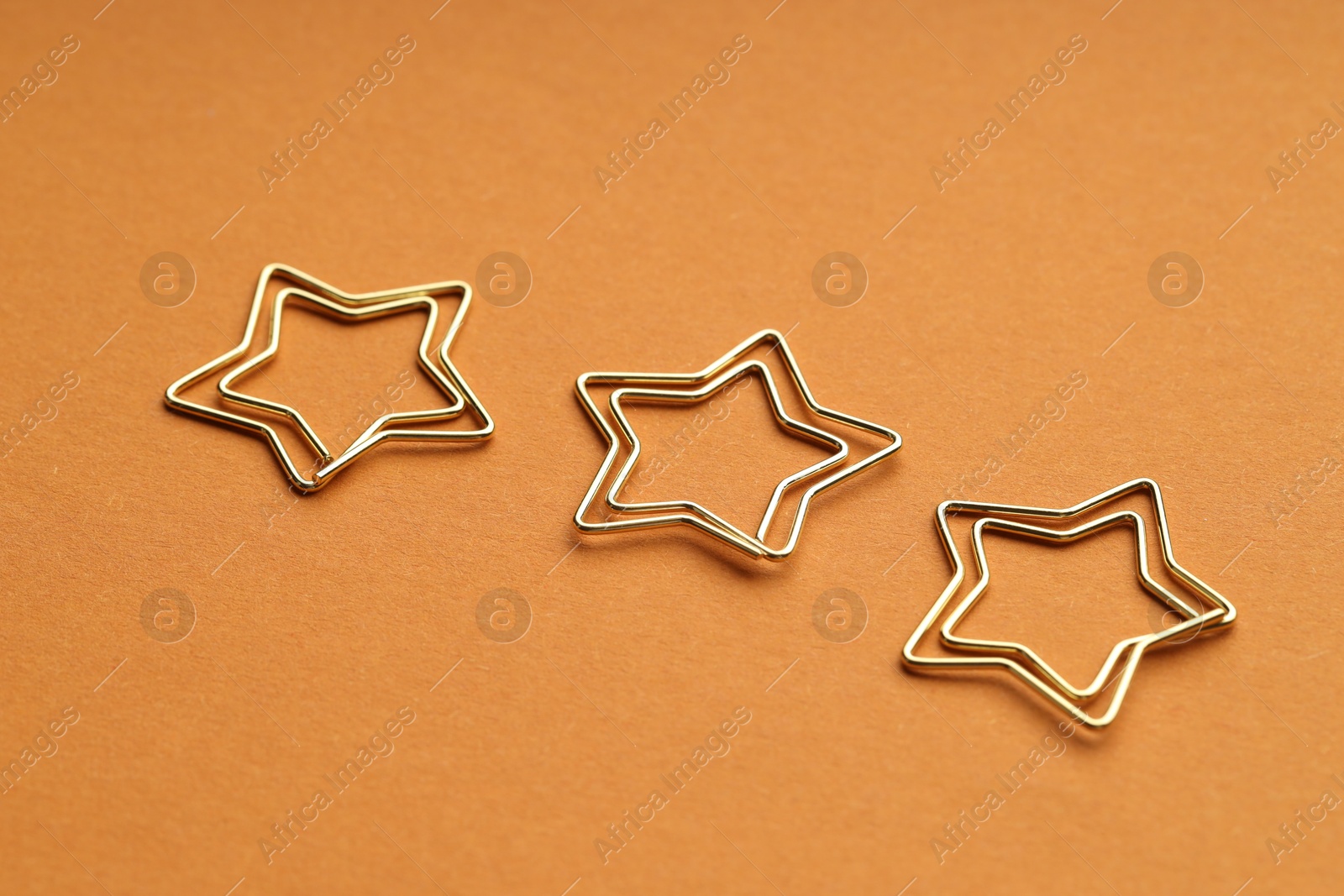 Photo of Star shaped paper clips on orange background