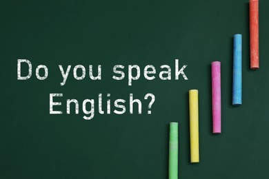 Image of Do You Speak English? text and pieces of colorful chalk on greenboard, top view. Language course