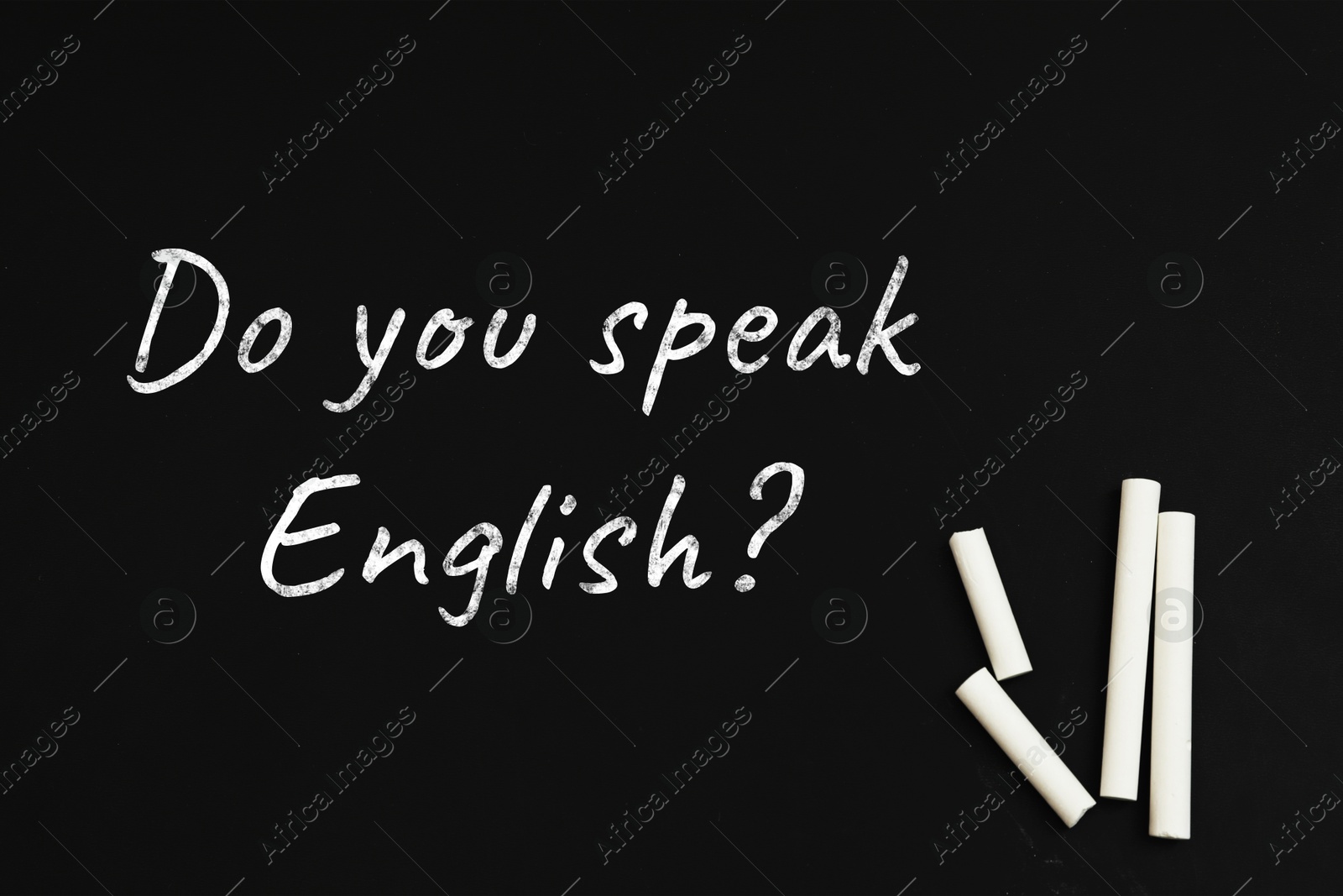 Image of Do You Speak English? text and pieces of white chalk on blackboard, top view. Language course