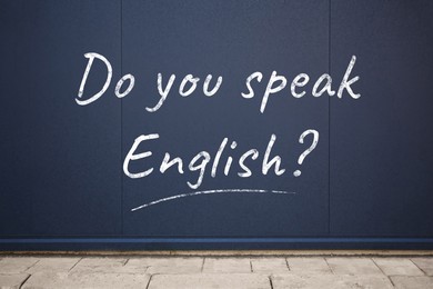 Image of Do You Speak English? text on dark blue wall outdoors. Language course