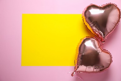 Photo of Heart shaped balloons and yellow card on pink background, flat lay. Space for text