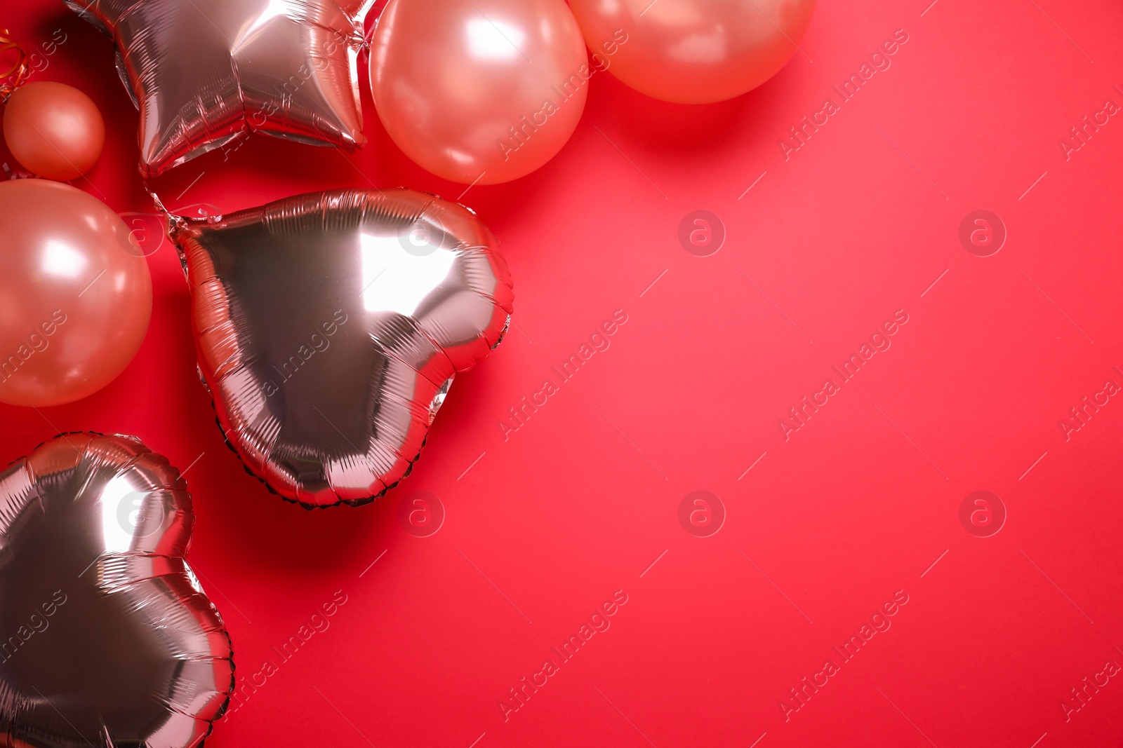 Photo of Colorful balloons on red background, flat lay. Space for text