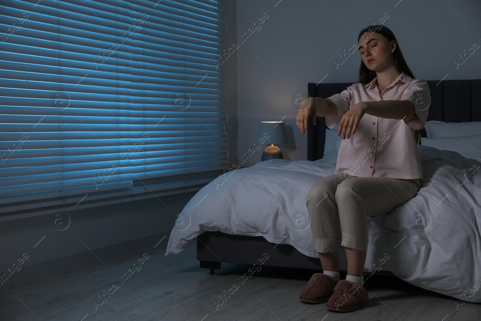 Photo of Young woman suffering from sleepwalking at home, space for text