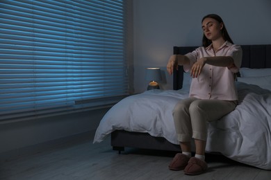 Photo of Young woman suffering from sleepwalking at home, space for text