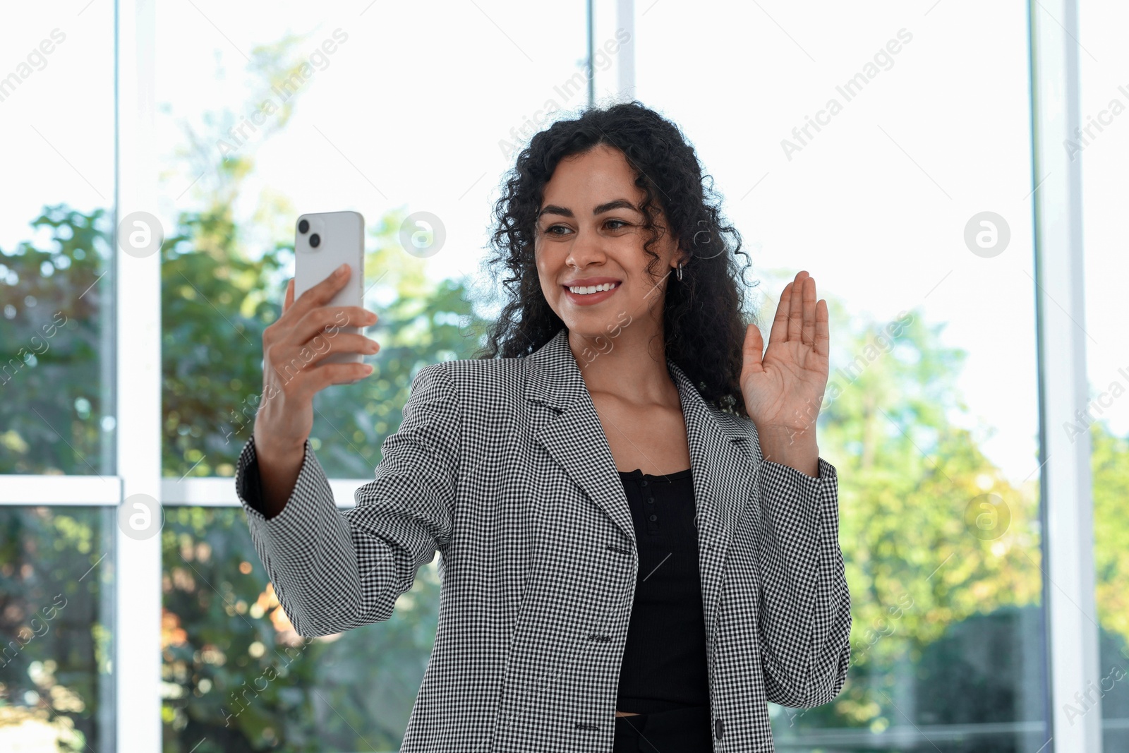 Photo of Portrait of young woman with phone wearing stylish suit indoors