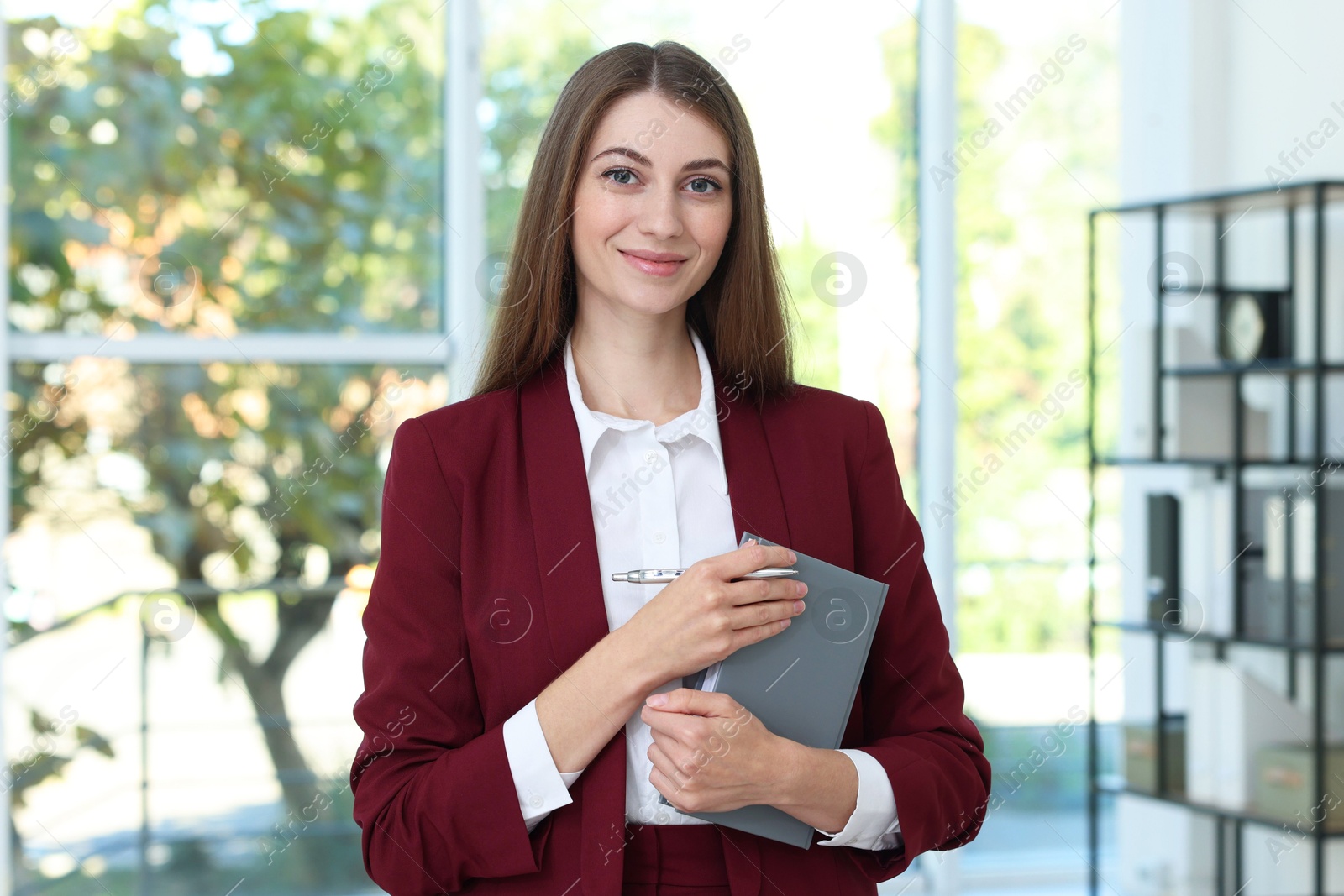 Photo of Portrait of young woman with book wearing stylish suit indoors