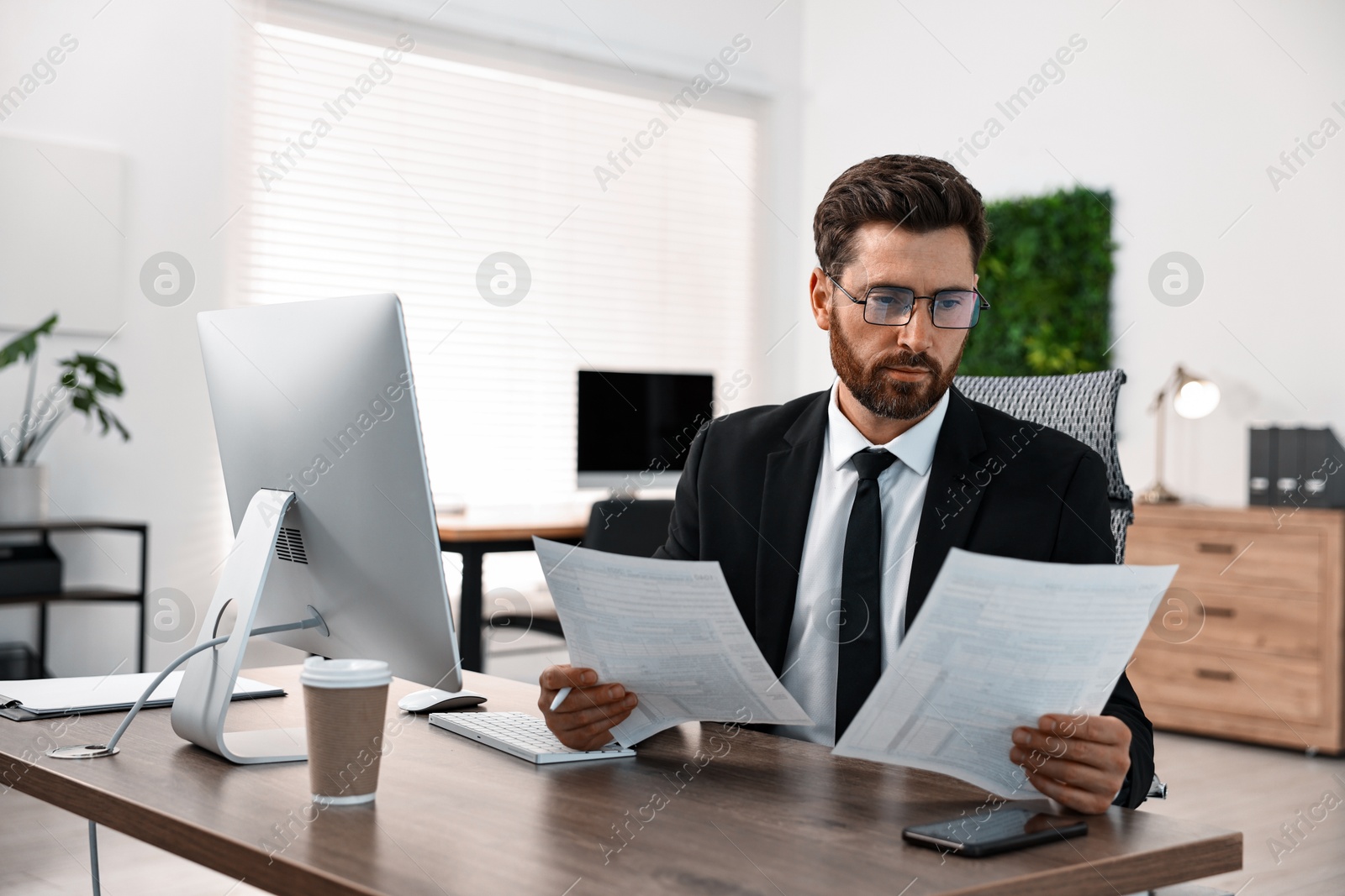 Photo of Man working with documents at table in office