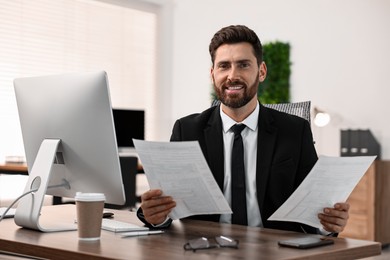 Photo of Man working with documents at table in office