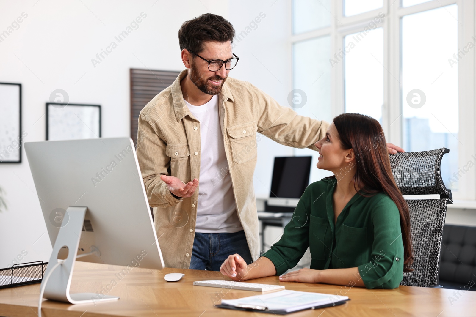 Photo of Colleagues working together at desk in office