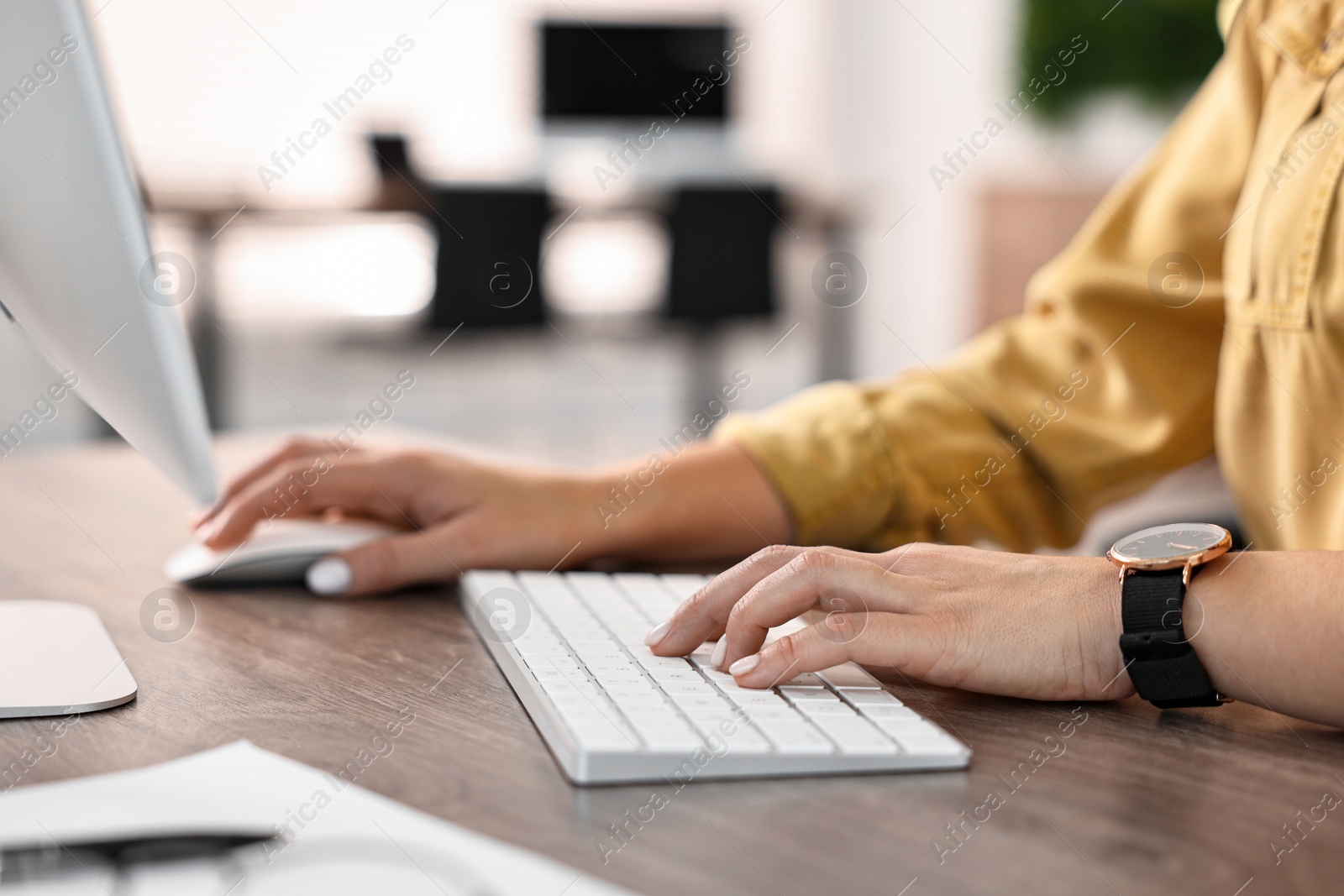 Photo of Woman working on computer at table in office, closeup