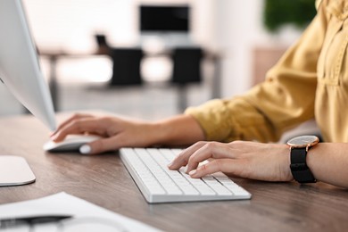 Photo of Woman working on computer at table in office, closeup