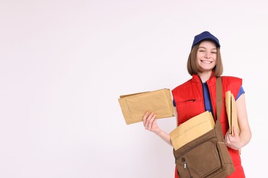 Photo of Happy postwoman with bag and envelopes on white background. Space for text