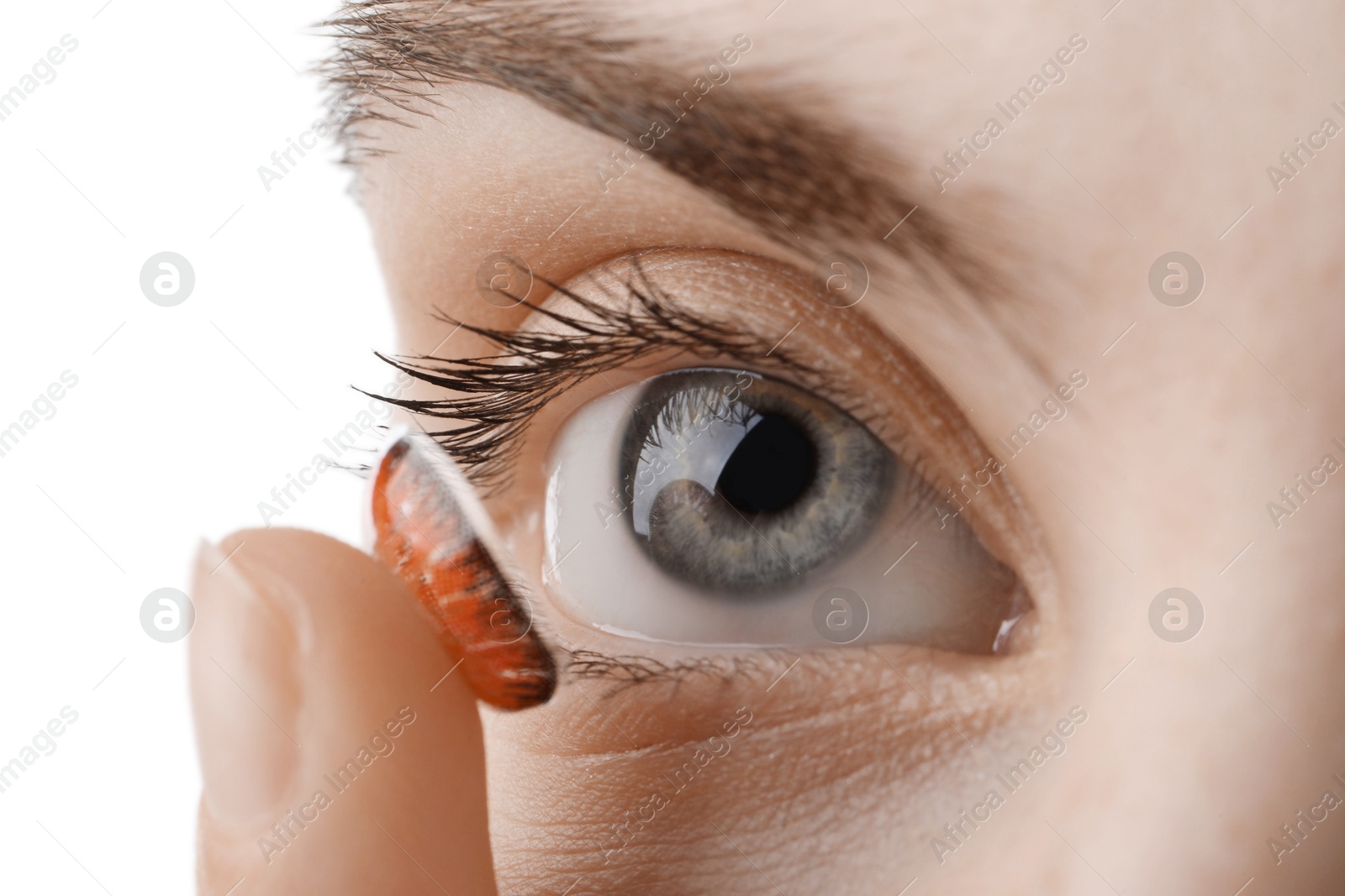 Photo of Woman putting in red color contact lens on white background, closeup