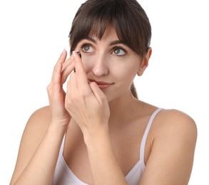 Young woman putting in color contact lens on white background