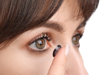 Woman putting in color contact lens on white background, closeup