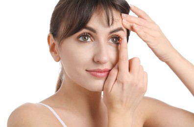 Photo of Young woman putting in red color contact lens on white background