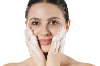 Beautiful woman washing her face with cleansing foam on white background, closeup