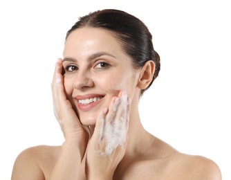 Photo of Smiling woman washing her face with cleansing foam on white background