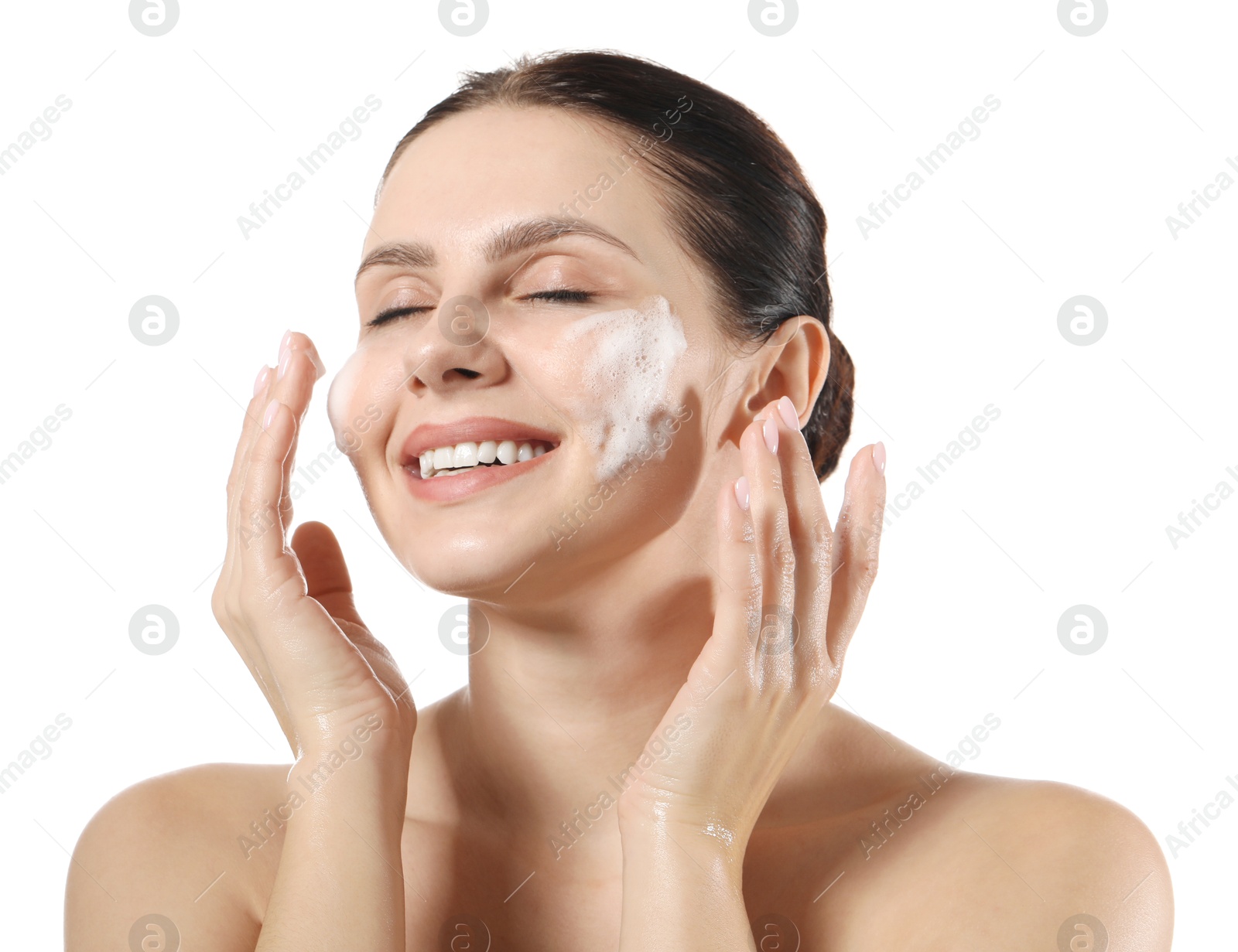 Photo of Smiling woman washing her face with cleansing foam on white background