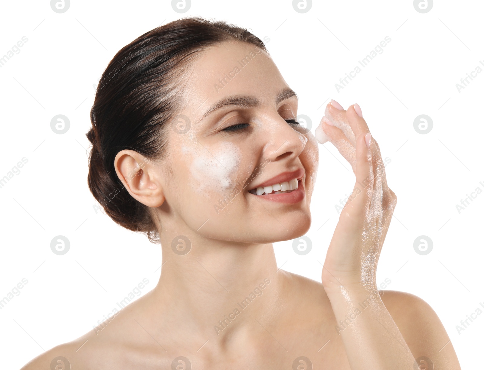 Photo of Smiling woman washing her face with cleansing foam on white background