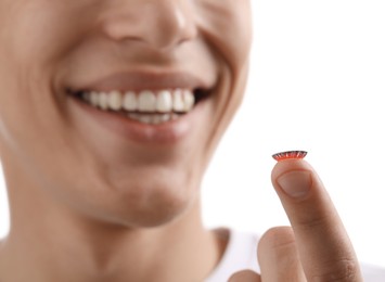 Photo of Man with color contact lens on white background, closeup. Selective focus