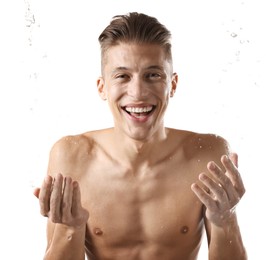 Photo of Smiling man washing his face on white background