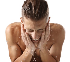 Photo of Smiling man washing his face on white background