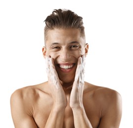 Photo of Smiling man washing his face with cleansing foam on white background